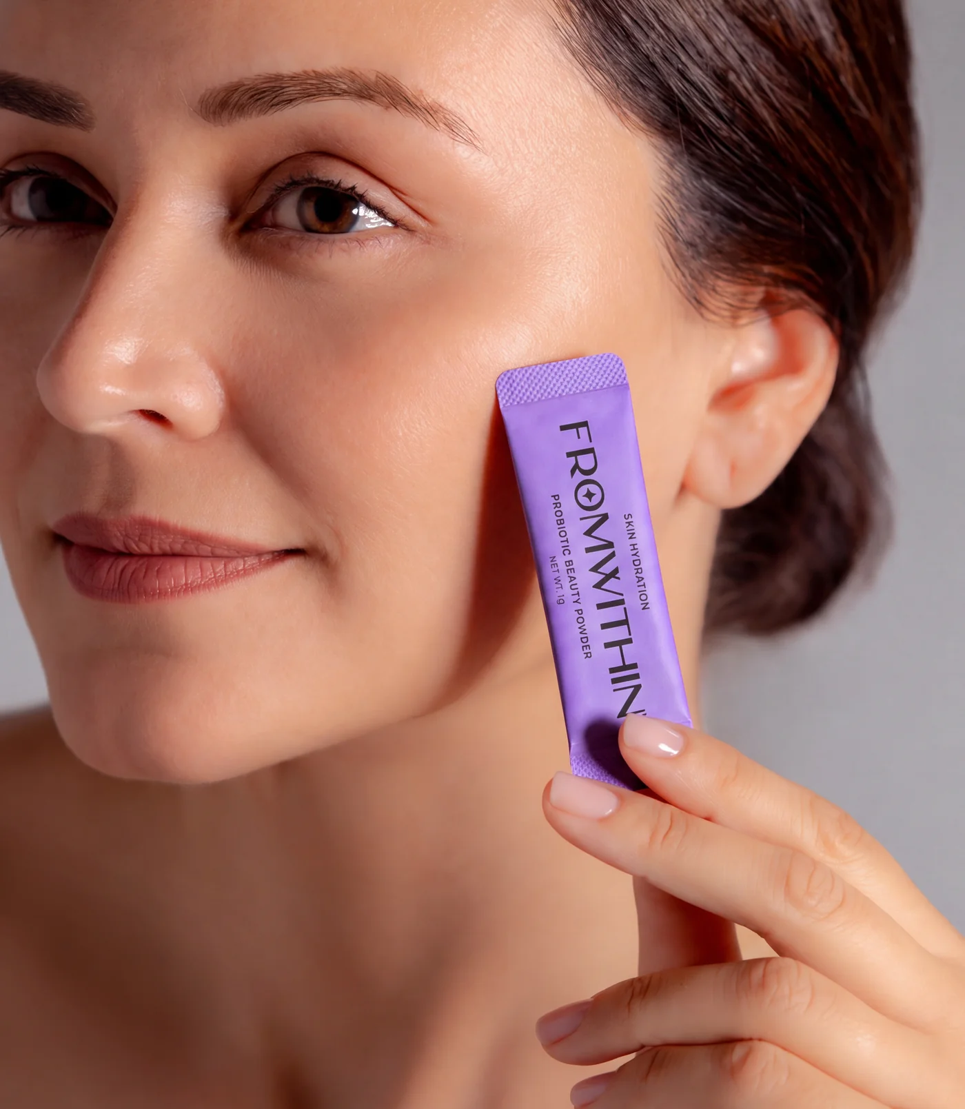 A FROMWITHIN sachet held against the cheek